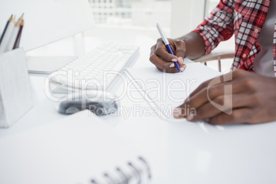 Casual businessman writing notes on paper