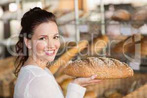 Pretty brunette holding loaf of bread