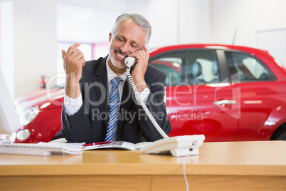 Smiling businessman using laptop on the phone