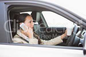 Woman drinking coffee on phone while driving