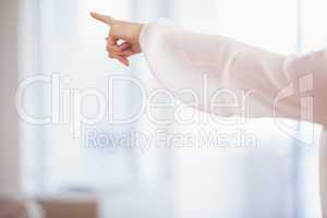 Mid section of young woman pointing with finger
