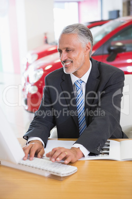 Smiling businessman using his laptop