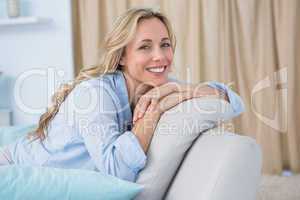 Cheerful pretty blonde sitting on couch