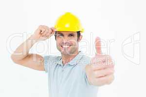 Architect wearing hardhat while showing thumbs up sign