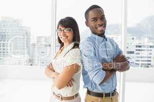 Smiling coworkers posing with arms crossed