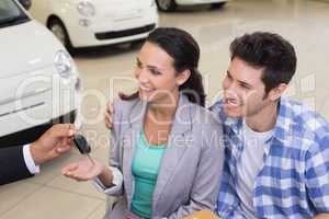 Smiling young couple receiving key