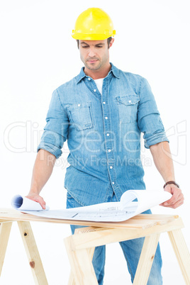 Architect analyzing blueprint at table