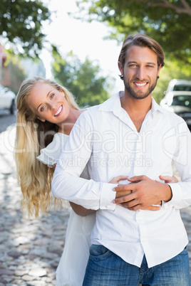 Attractive couple hugging each other and smiling at camera