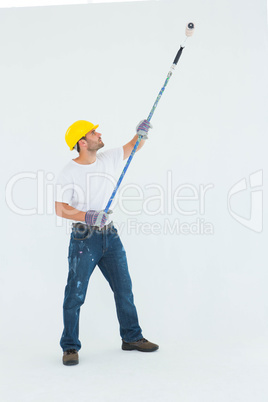 Man painting with roller on white background