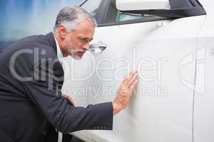 Focused businessman looking at the car body