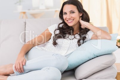 Pretty brunette smiling on couch