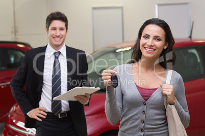 Female driver showing a key after bying a new car