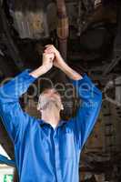 Mechanic examining under the car