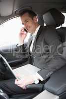 Businessman working in the drivers seat