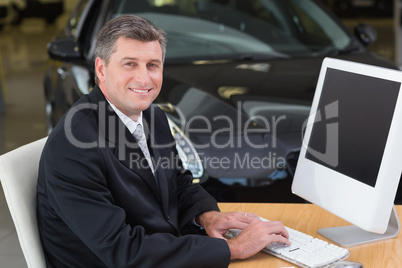 Smiling businessman typing on laptop