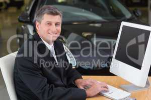 Smiling businessman typing on laptop