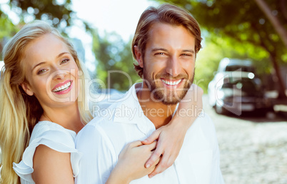 Attractive couple hugging each other and smiling at camera