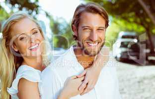 Attractive couple hugging each other and smiling at camera