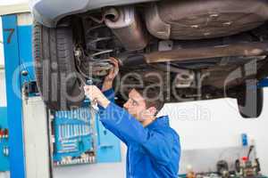 Mechanic examining under the car