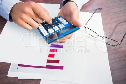 Close up of finger using calculator at desk