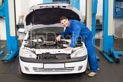 Mechanic examining under hood of car