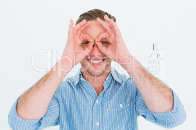 Smiling doctor forming eyeglasses with his hands