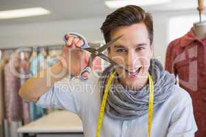 Smiling student holding pair of scissors