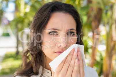 Pretty brunette blowing her nose