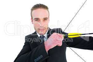 Serious businessman shooting a bow and arrow