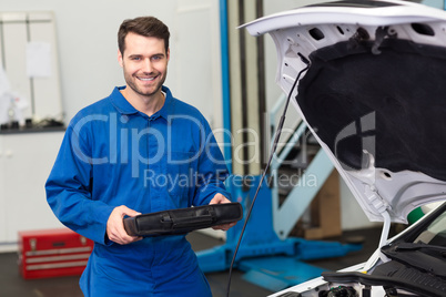 Mechanic examining under hood of car