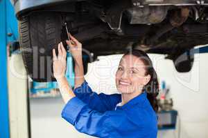 Smiling mechanic adjusting the tire