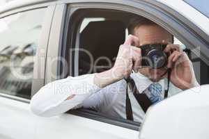Businessman taking picture while sitting in the drivers seat