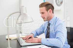 Serious businessman using his laptop