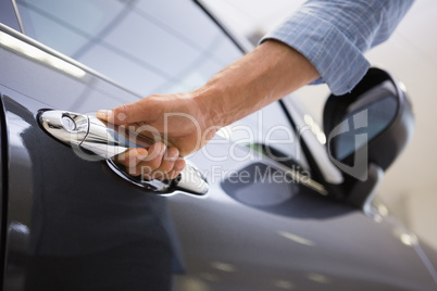 Man holding a car door handles