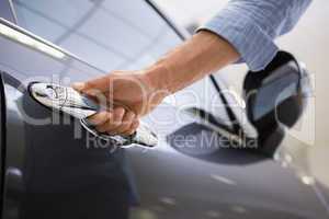 Man holding a car door handles