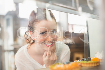 Pretty brunette looking at tarts