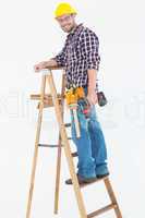 Repairman climbing ladder while holding power drill