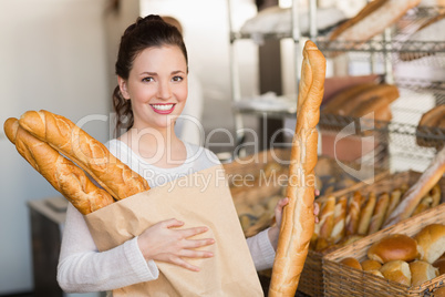 Pretty brunette holding bag of bread