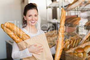 Pretty brunette holding bag of bread