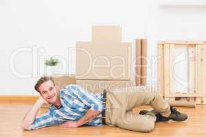 Happy man posing with moving boxes at home