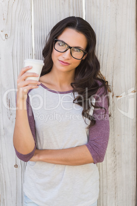 Pretty brunette holding take away coffee