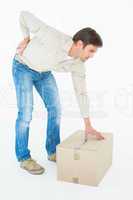 Delivery man with cardboard box suffering from backache