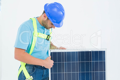 Construction worker examining solar panel