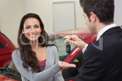 Businessman giving car key while shaking a customer hand