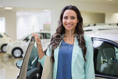 Pretty customer standing next to her car