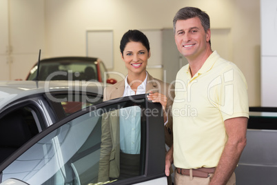 Businesswoman showing a car interior to her customers