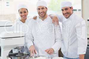 Team of bakers smiling at camera