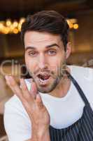 Handsome waiter making tasty gesture