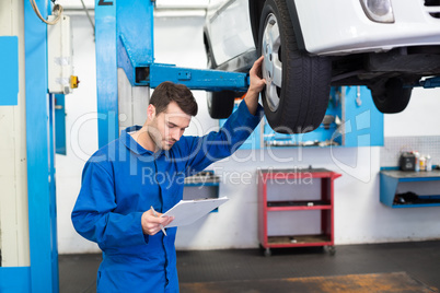 Mechanic looking at car tires