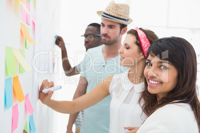 Portrait of smiling woman with his colleagues behind her